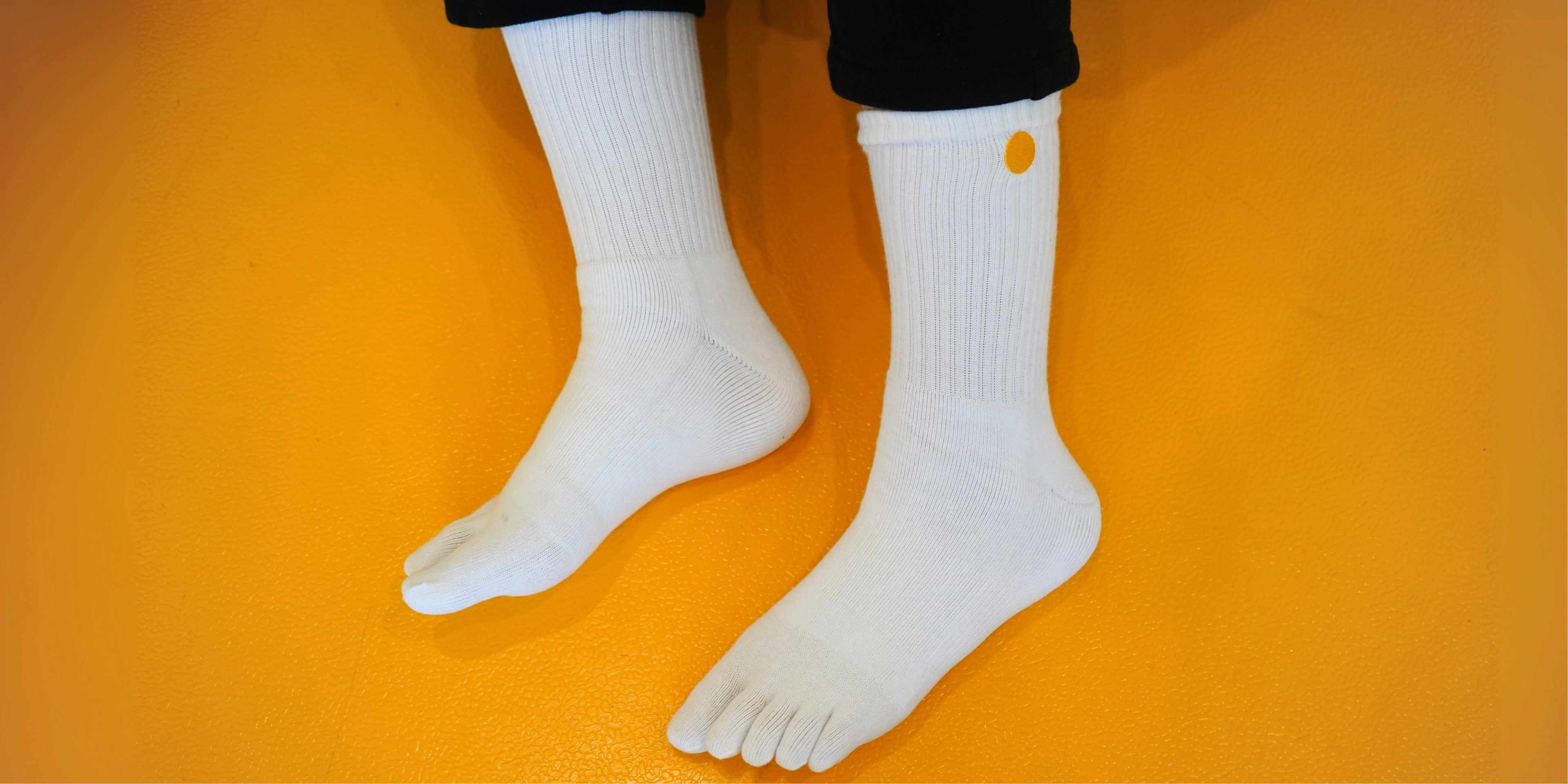 White Toe socks with a small Valuura  Logo on an orange background